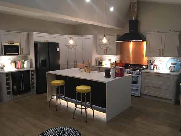 kitchen renovation with island and extractor fan with copper splashback